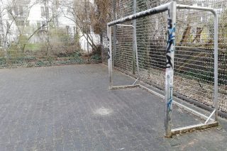 Ein gepflasterter Fußballplatz mit Tor